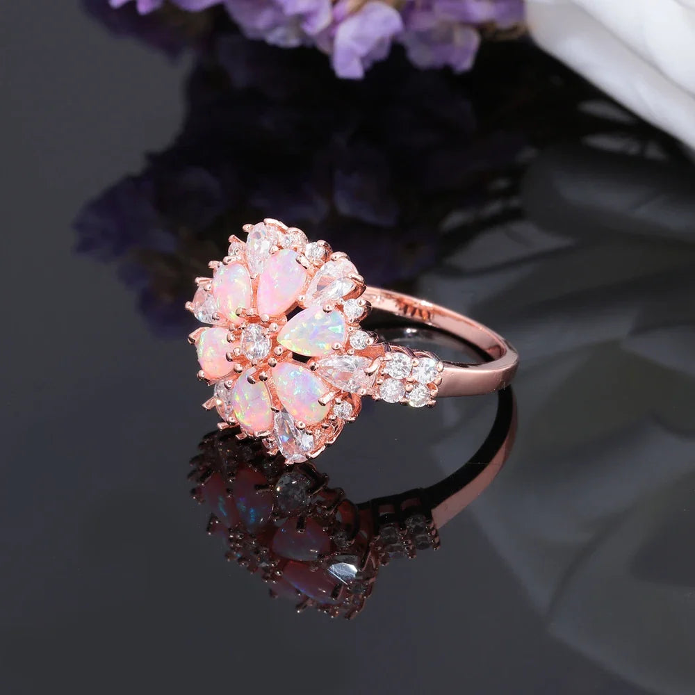 Large Pink Fire Opal Stone Rose Gold Crystal Flower Ring Adorned with Dazzling Gemstones.